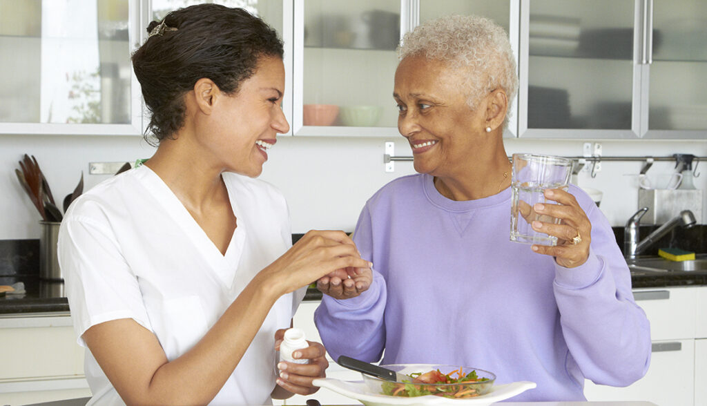 African American woman taking medication and eating lunch